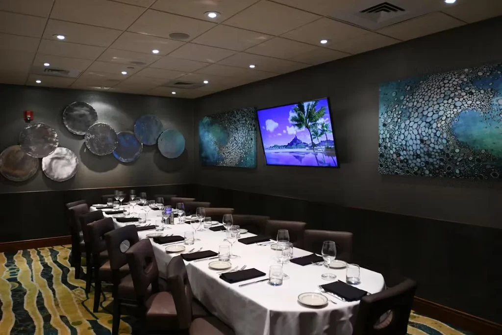 Elegantly set private dining room featuring artworks and a tropical TV.