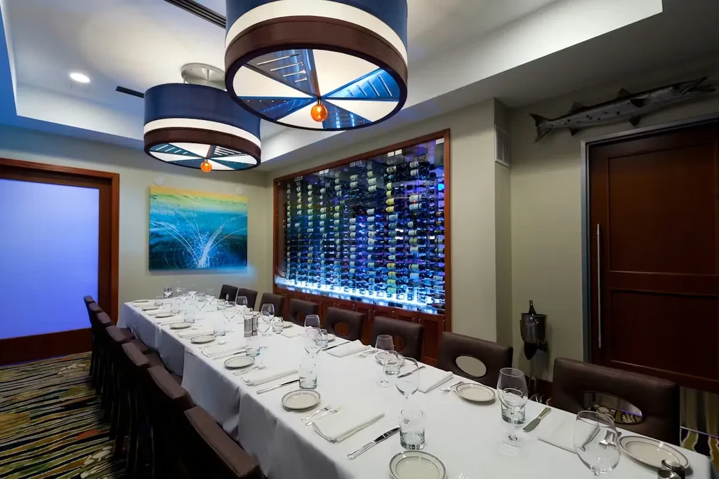 Private dining room with set table, wine display, and taxidermy fish.