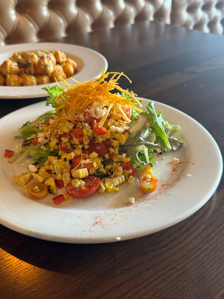 Vibrant salad and fried food on a restaurant table.