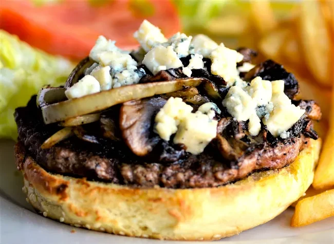 Beef burger with sautéed mushrooms, onions, and blue cheese.