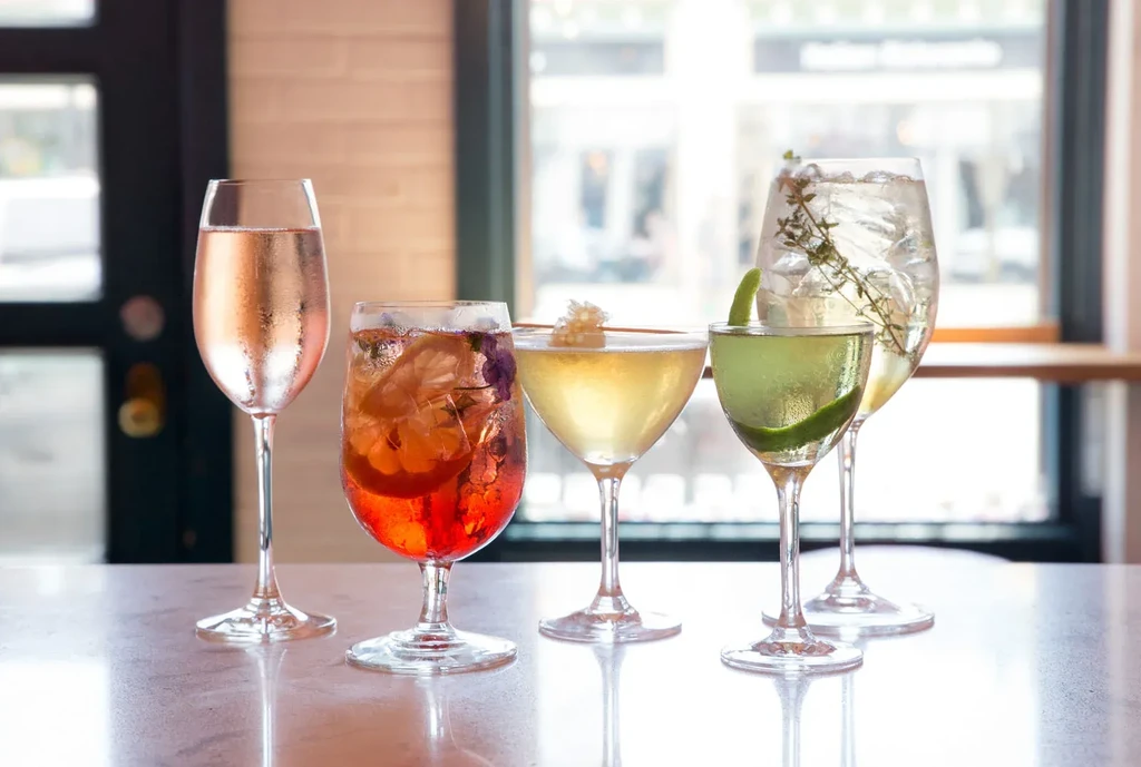 Five diverse cocktails, each with unique color and garnish.