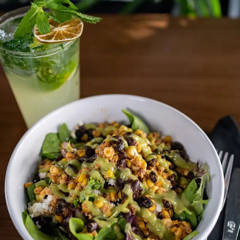 Salad with roasted corn, black beans, cheese, and a mint-lime beverage.