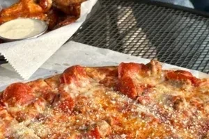Heavily topped rectangular pizza and golden-brown fried chicken pieces.