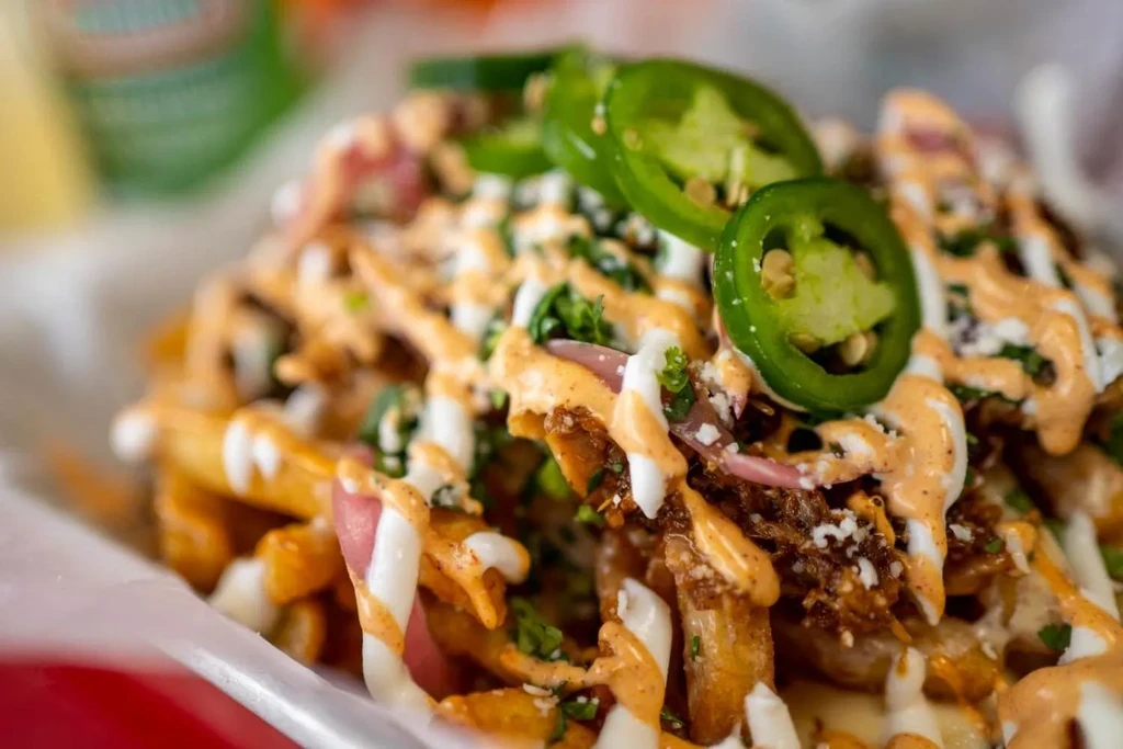 Golden loaded fries with pulled meat, creamy sauces, jalapeños, and cheese.