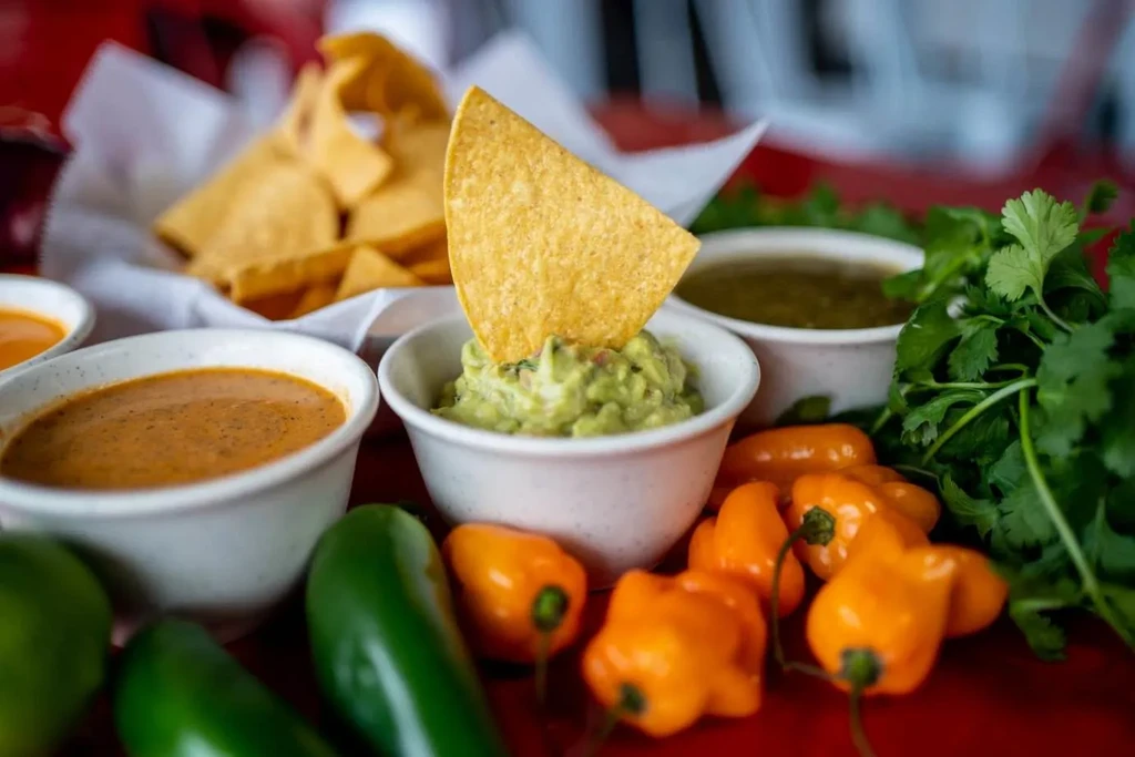 Close-up of fresh Mexican dips, peppers, and tortilla chips.