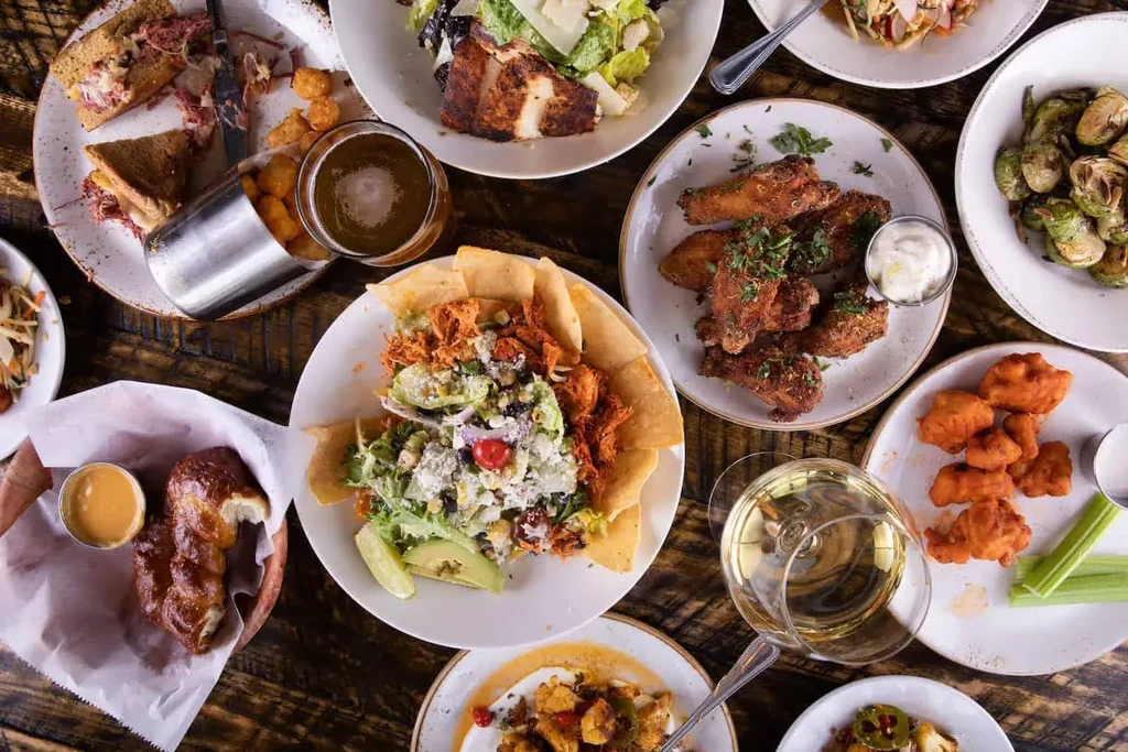 Overhead view of a rustic table laden with diverse food and drinks.
