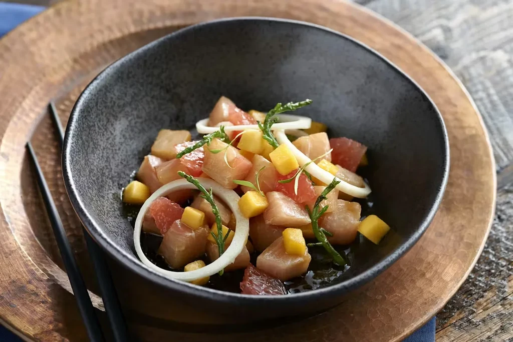 Vibrant cubed fish ceviche with mango, grapefruit, and herbs.