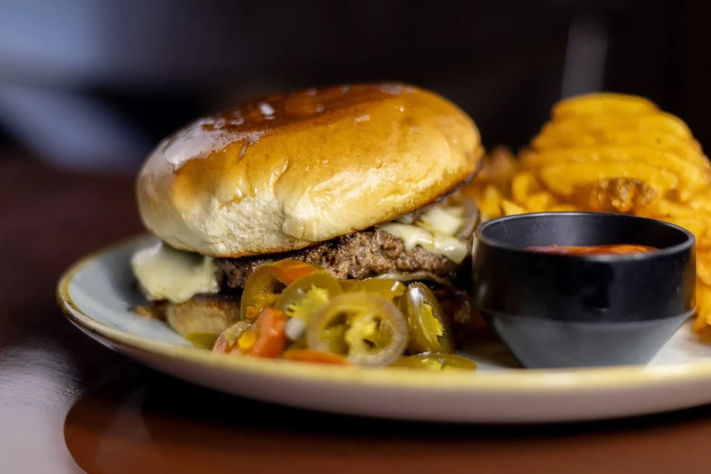 Double-patty burger, waffle fries, and side of pickles.