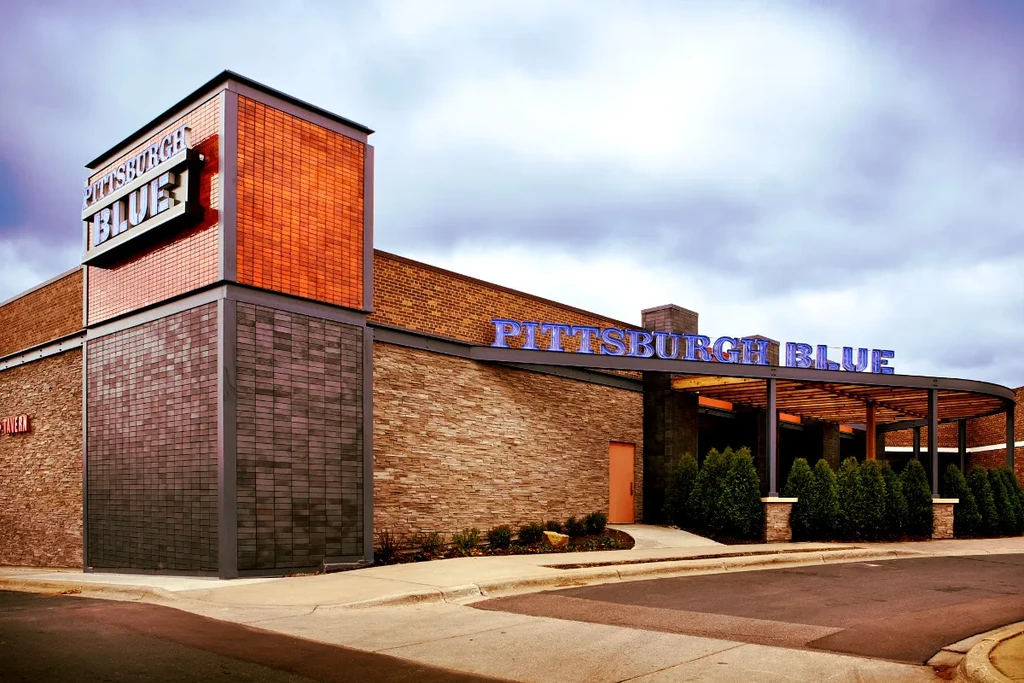 Modern "Pittsburgh Blue" restaurant exterior with prominent vertical and horizontal signs.