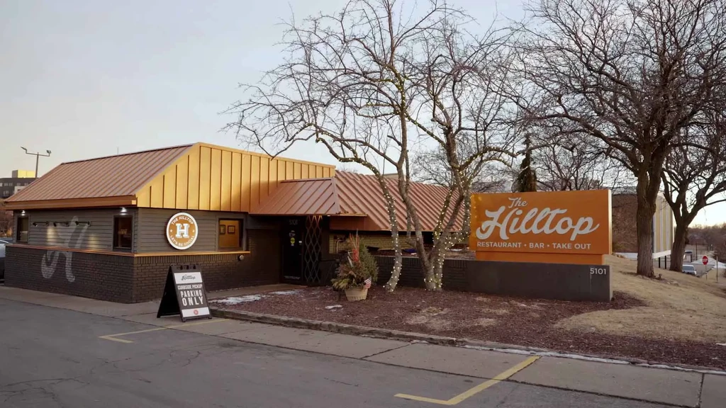 The Hilltop restaurant exterior with two-toned roof and "CURBSIDE PICKUP" sign.