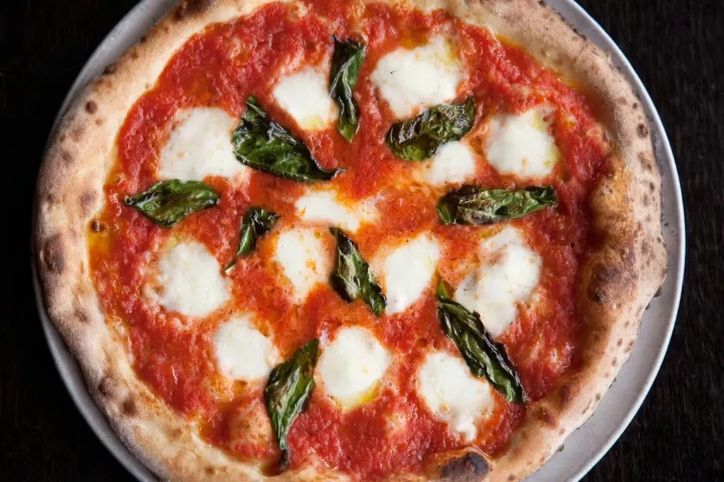 Freshly baked Neapolitan pizza with tomato sauce, mozzarella, and basil.