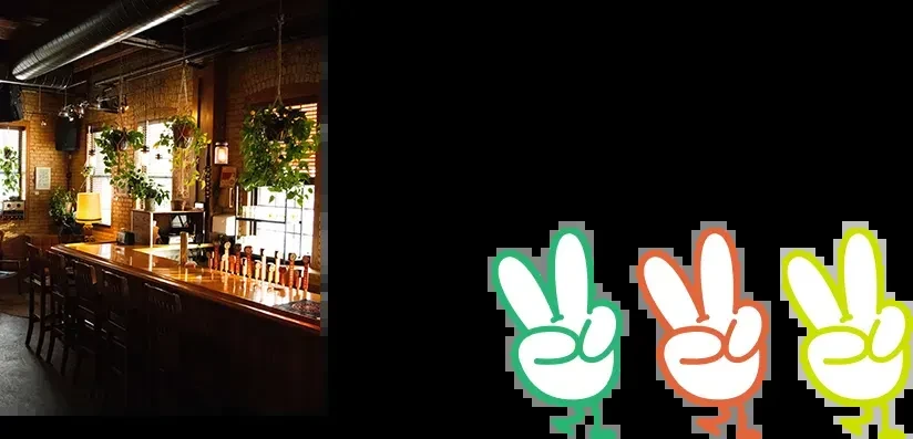 Rustic bar interior with a wooden counter, beer taps, and plants.