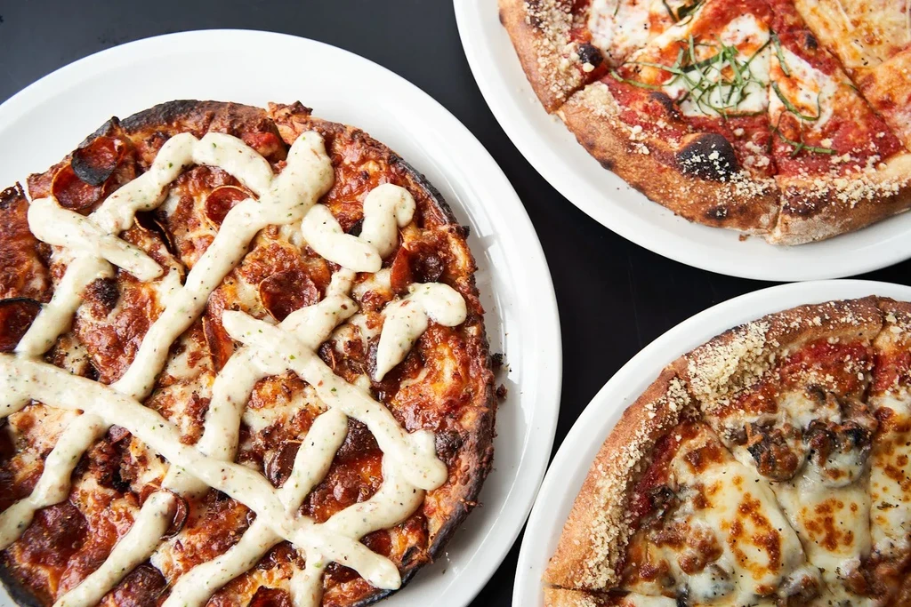 Three pizzas: pepperoni with white sauce, classic Margherita, and mushroom.