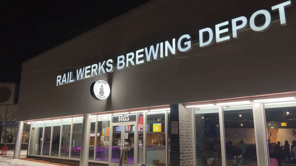 Illuminated, open Rail Werks Brewing Depot exterior at night, snow.