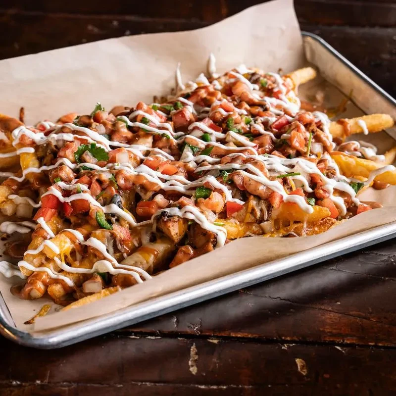Generous loaded fries with cheese, chicken, tomatoes, green onions, sauces.