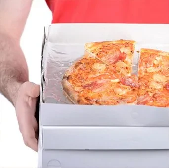 Person holds three white pizza boxes; one open to partially eaten pizza.