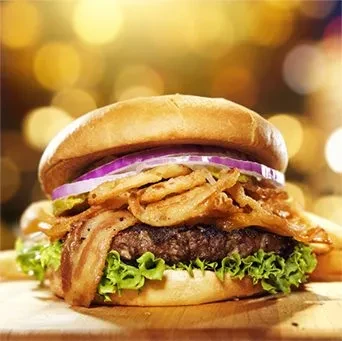 Gourmet hamburger with bacon, crispy fried onions, lettuce, and pickles.