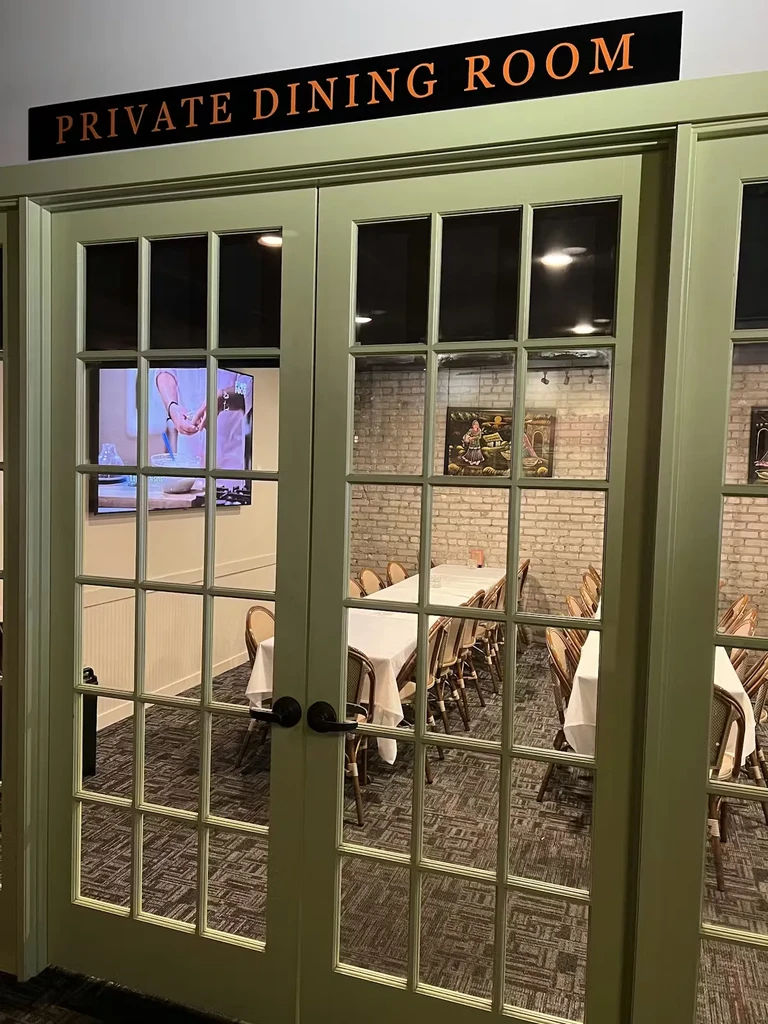 Private dining room with French doors, set tables, and cooking show.