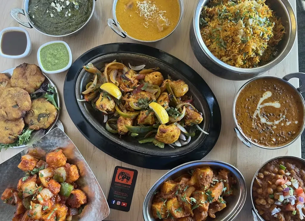 A large, overhead spread of various Indian dishes from Curry Corner.