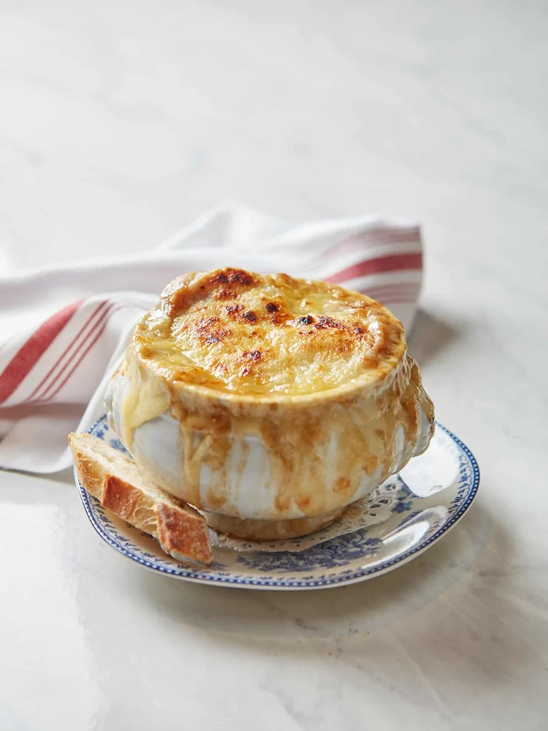 French onion soup topped with melted golden-brown cheese and a toasted baguette.