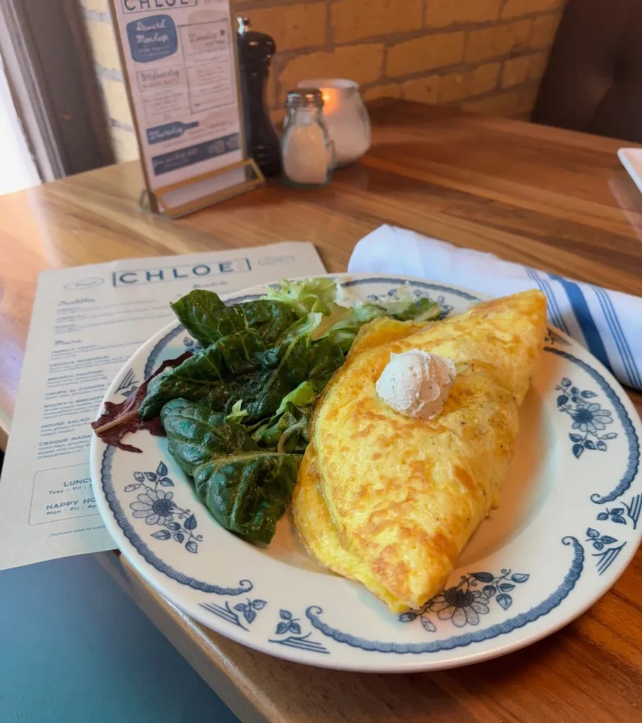 Golden omelet with creamy topping, fresh lettuce, and Chloe menu.