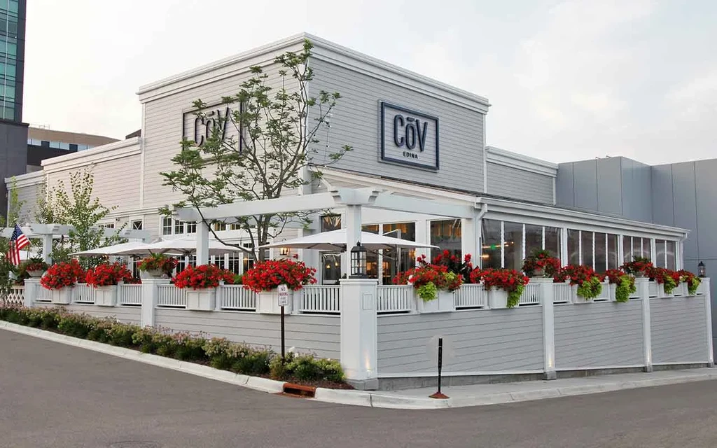 COV Edina restaurant exterior, gray with white trim, red flowers, patio.