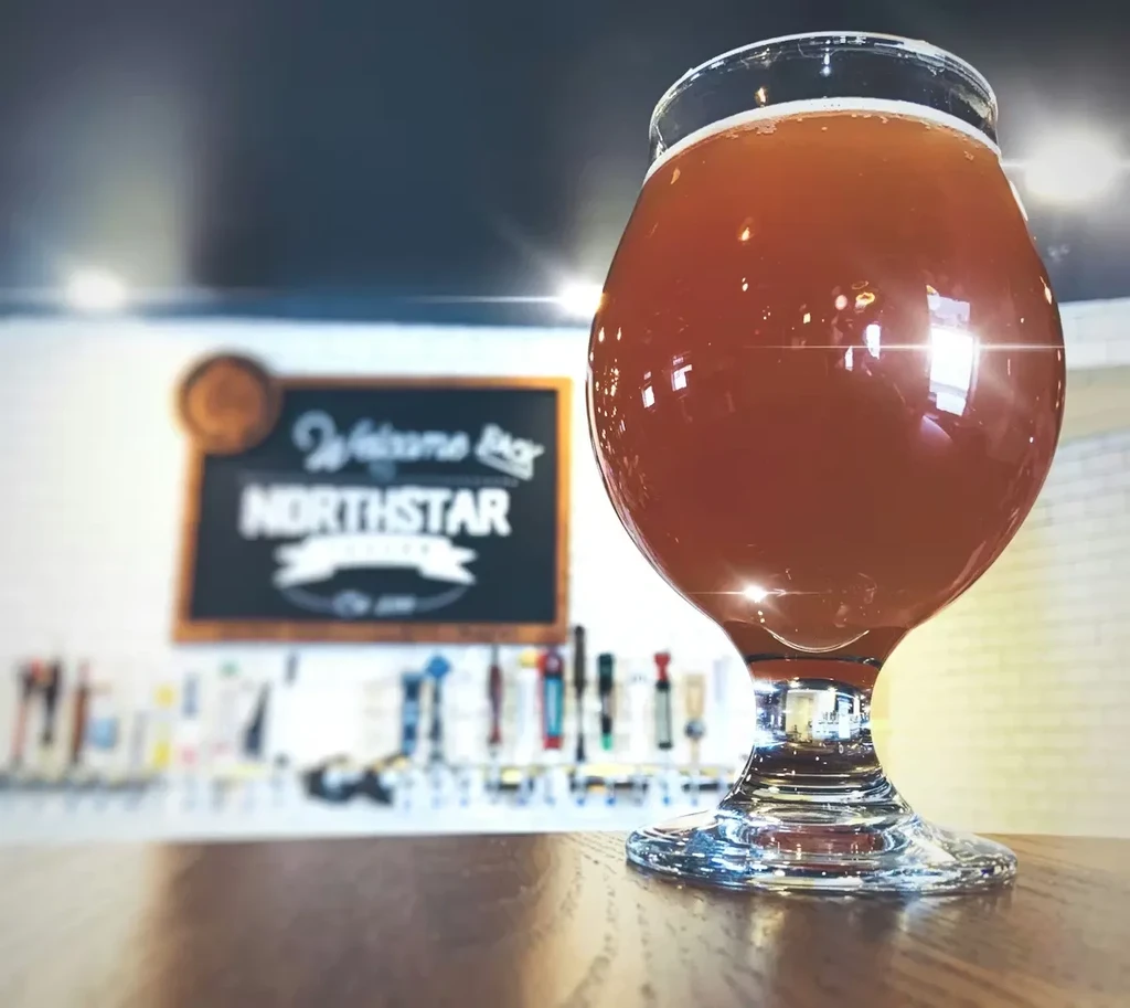 A glass of amber beer with foam at Northstar Brewery.