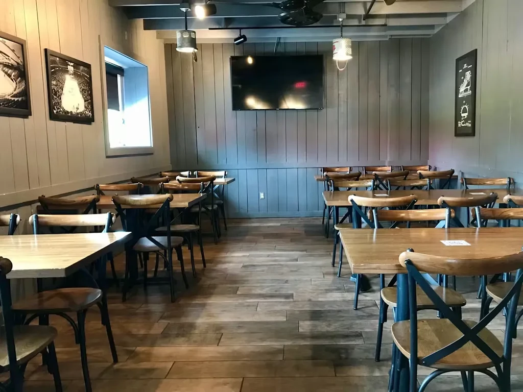 Casual restaurant interior with wooden tables, chairs, and rustic-modern decor.