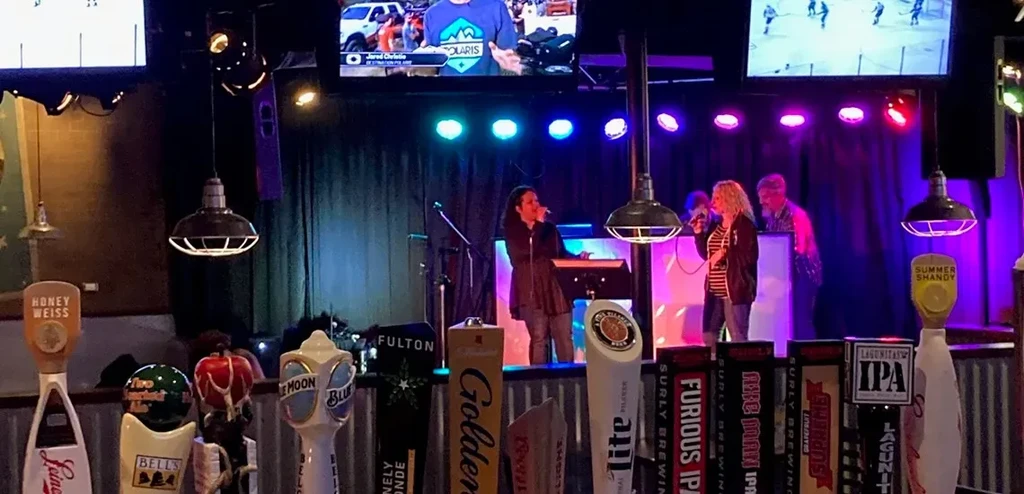 Live music in a bar: two women sing, many distinct beer taps.