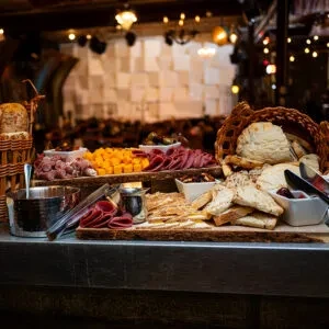 A well-presented buffet with cold meats, cheese, and various breads.