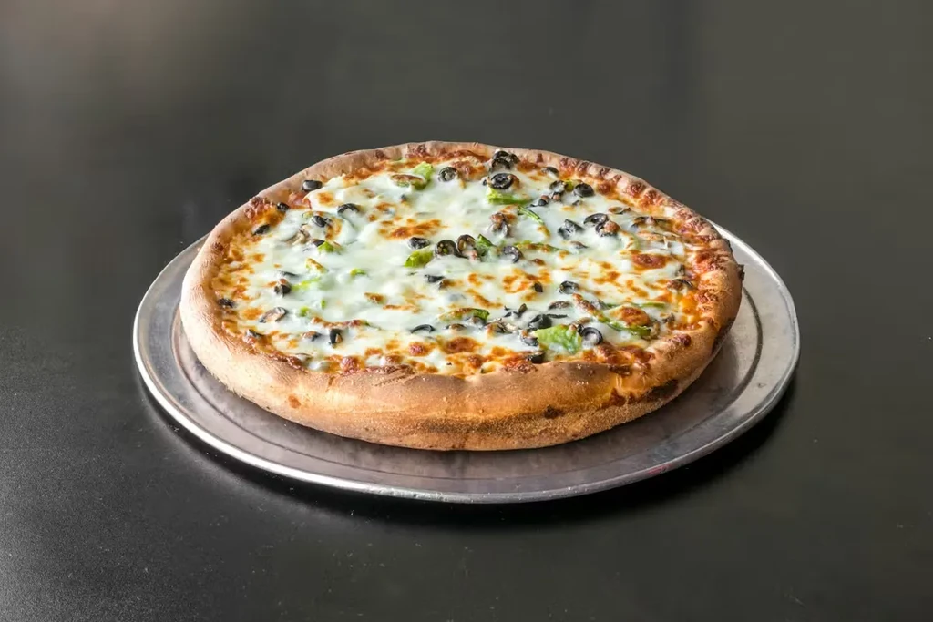 Freshly baked pizza with mozzarella, black olives, and green peppers on a pan.