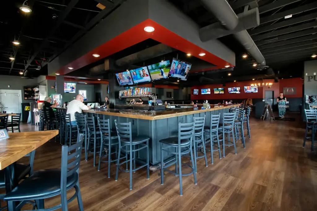 Large modern sports bar interior with beer taps and TVs.