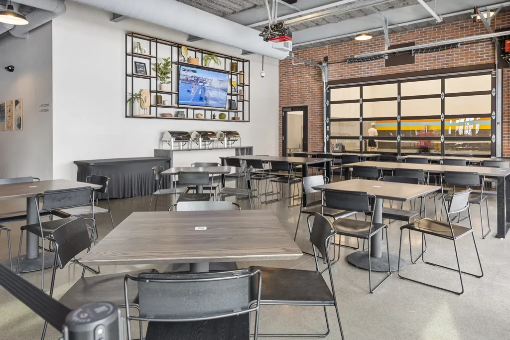 Empty modern industrial-chic dining hall with buffet and TV.