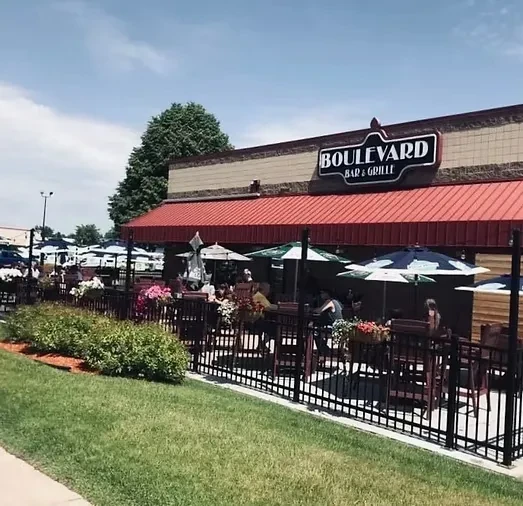 Exterior of Boulevard Bar & Grille, featuring a shaded outdoor patio with diners.