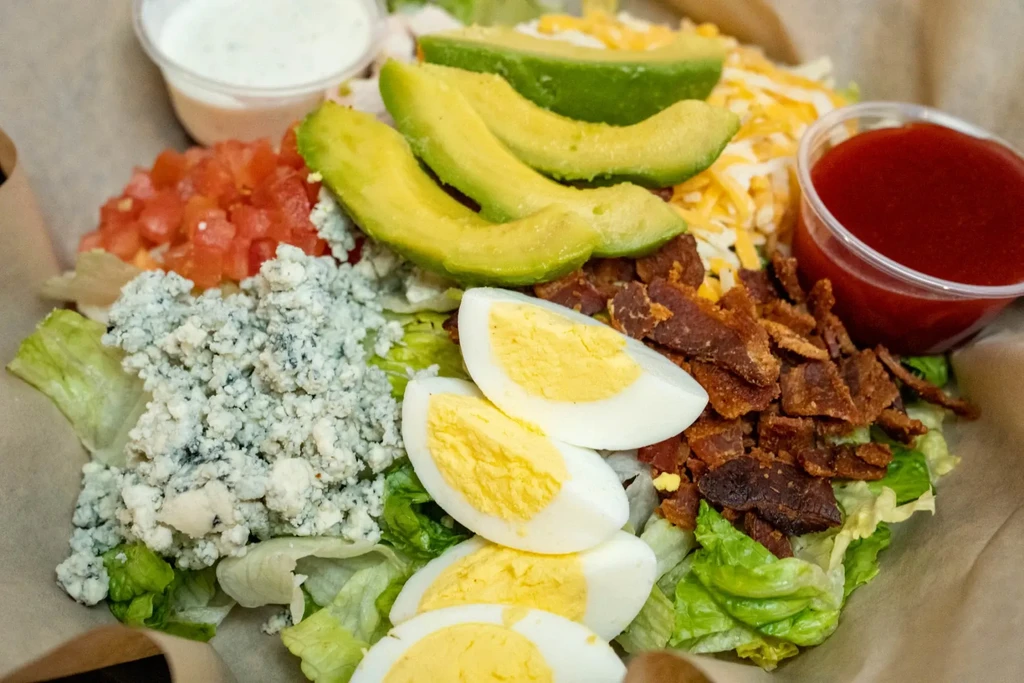 Generous Cobb salad with hard-boiled eggs, avocado, bacon, and cheeses.