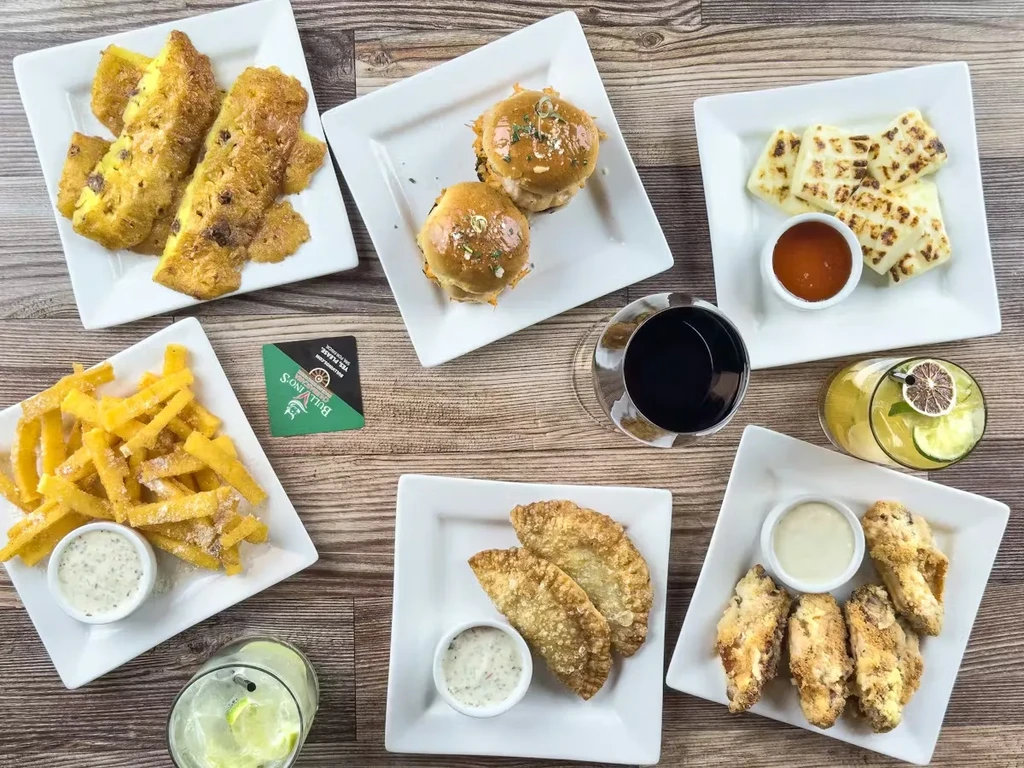 Overhead view of Bullivino's diverse small plates and drinks on a wooden table.