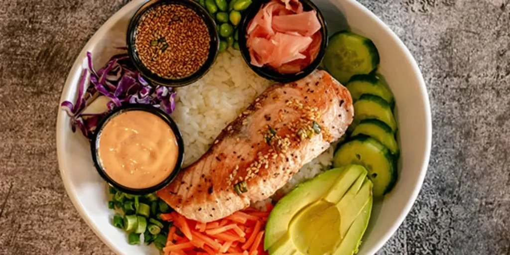 Overhead shot of a colorful salmon poke bowl with fresh toppings.