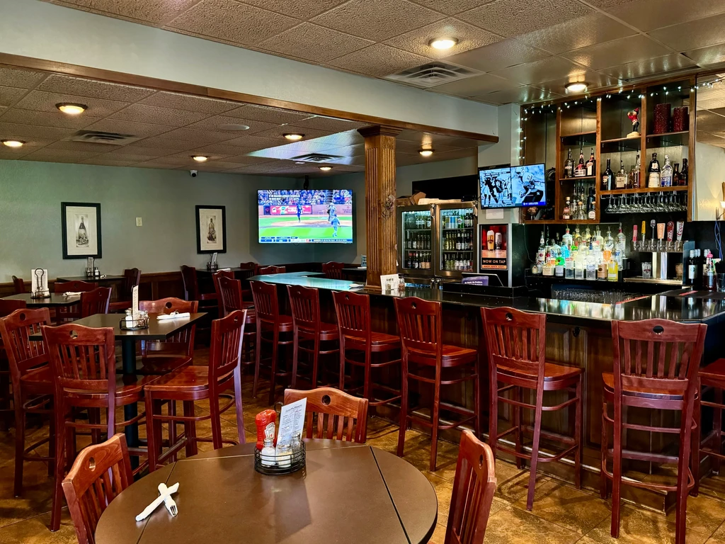 Warm casual restaurant interior featuring dining, a bar, and sports TVs.