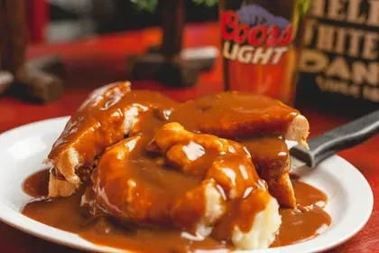 Hot open-faced meat sandwich with mashed potatoes and brown gravy.