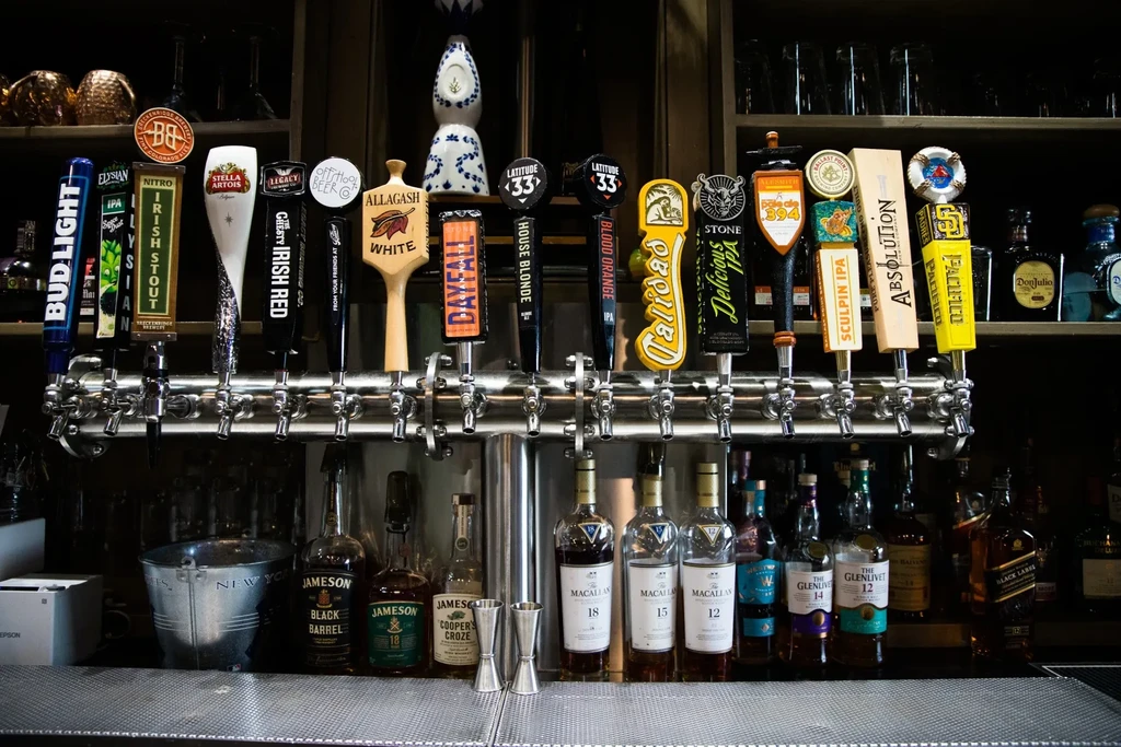 Professional bar with many beer taps and various liquor bottles.