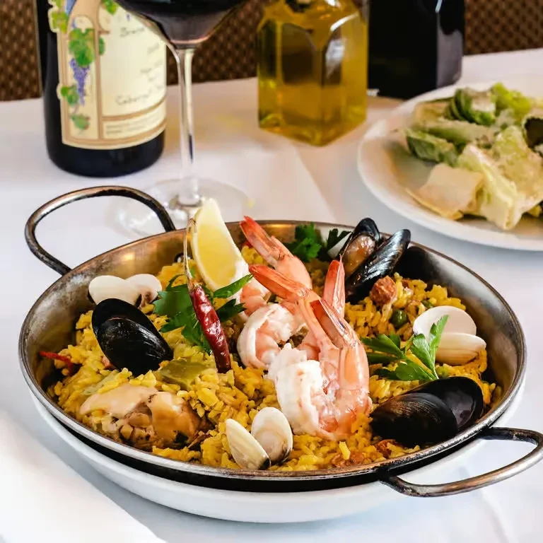 Paella with shrimp, mussels, chicken, vegetables, lemon; wine and oil.