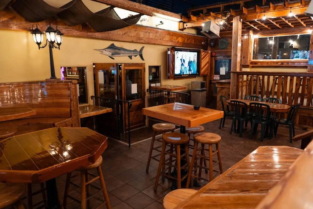 Rustic restaurant interior with light wood, varied seating, and marlin decoration.