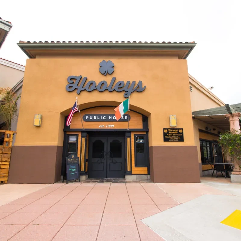 Exterior of Hooleys Public House with shamrock logo and flags.