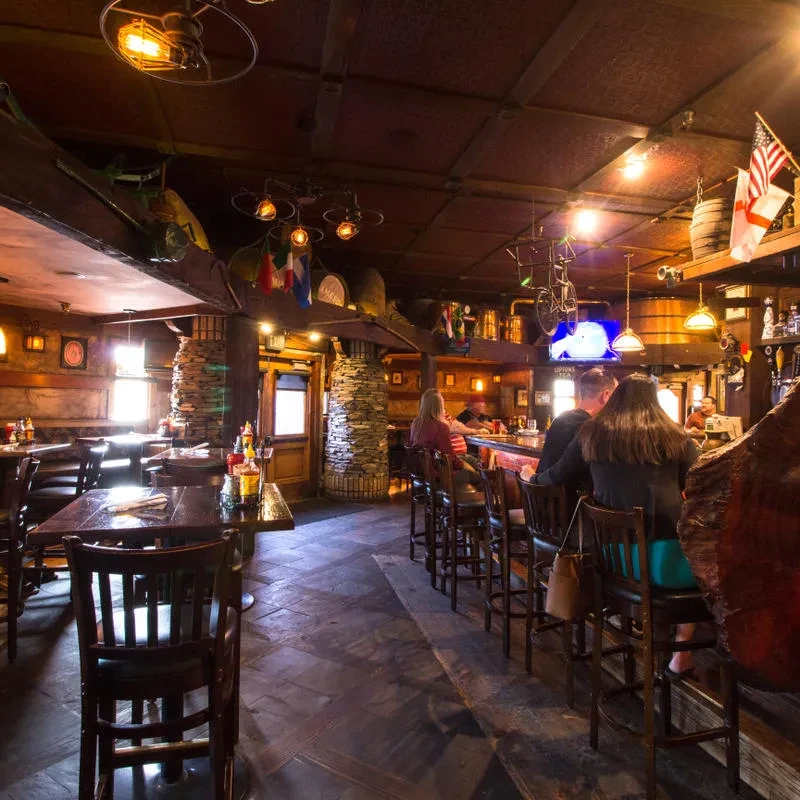 Warmly lit, rustic restaurant interior with eclectic decor and patrons.