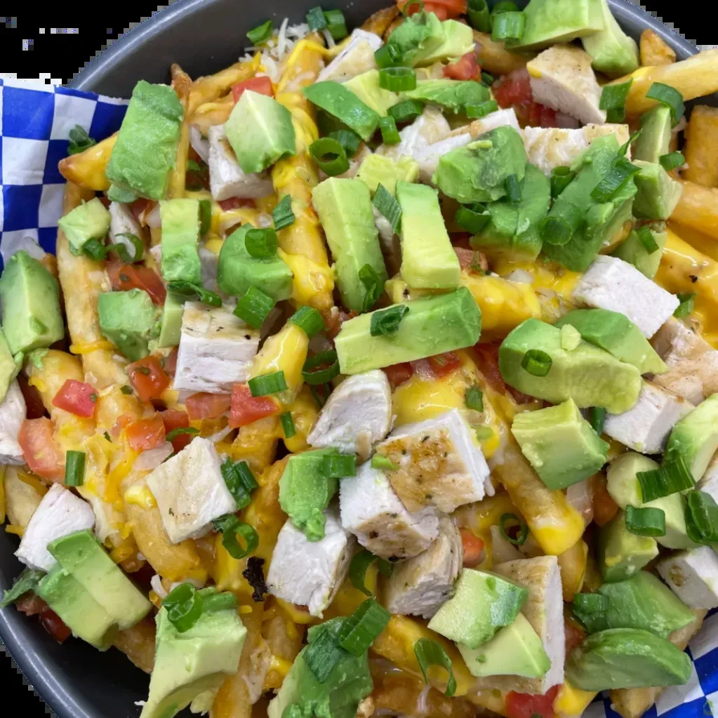 Loaded fries with cheese, chicken, avocado, tomatoes, and green onions.