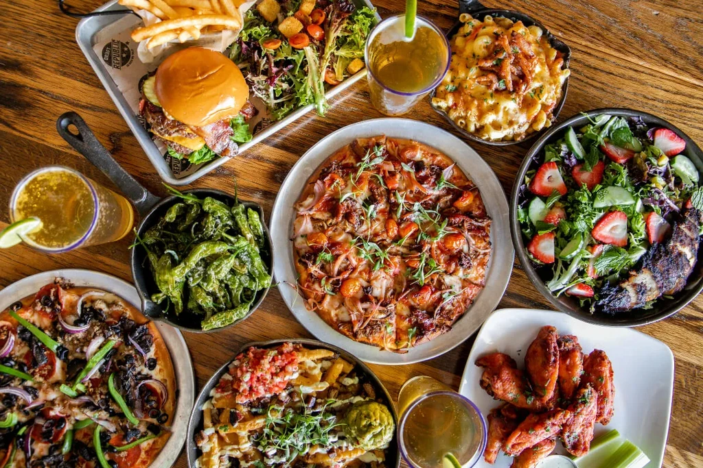 Flat-lay: wooden table with gourmet comfort food and drinks.