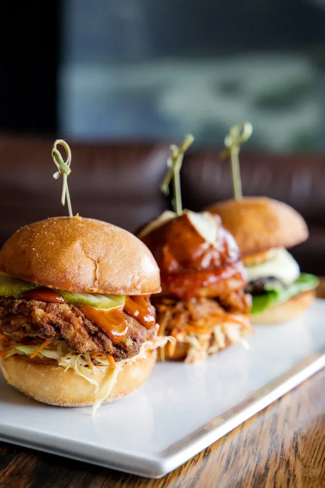 Three gourmet sliders: fried chicken, pulled meat, and beef.