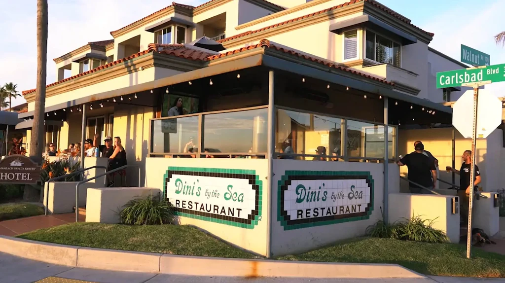 Mediterranean-style Dini's by the Sea restaurant, with patrons on patio.