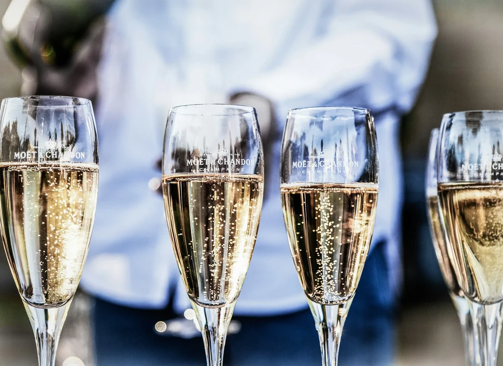 Close-up: Moët & Chandon champagne flutes with visible golden bubbles.