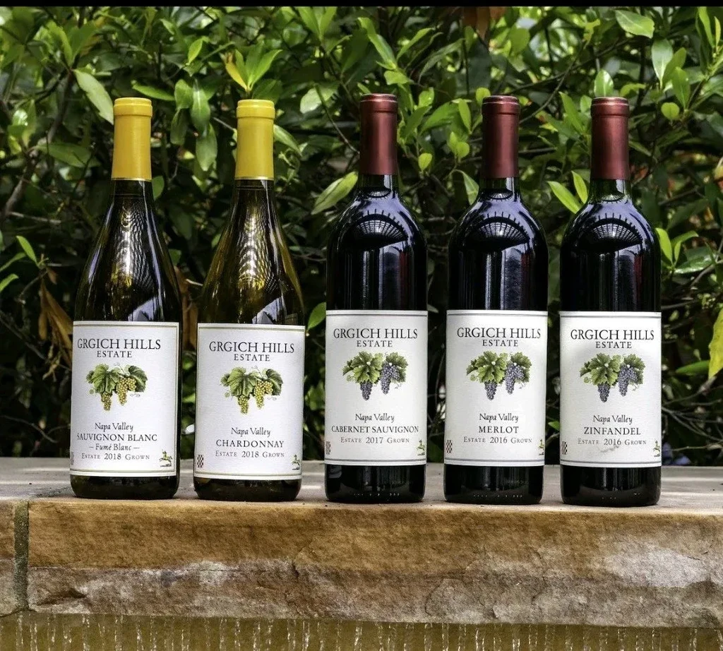 Five Grgich Hills Estate wines: two white, three red, on a ledge.